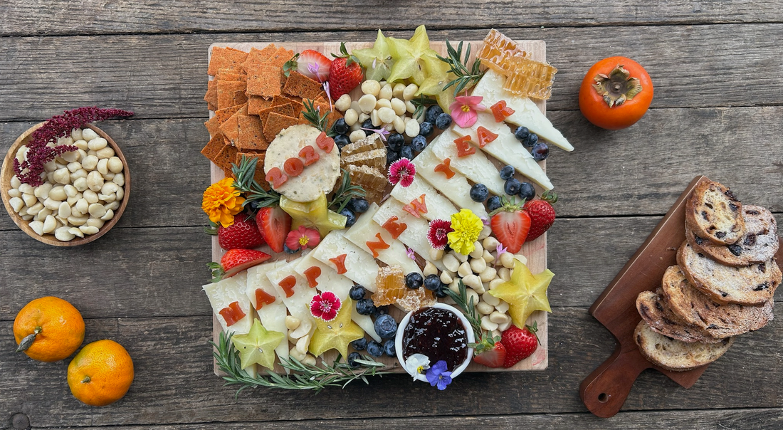 Fresh charcuterie board with cheese, honey, nuts, fruits and bread with the words "Happy New Year 2025".