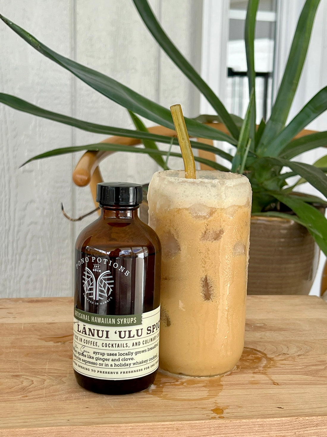 A cup of cold brew coffee topped with creamy pumpkin ʻulu foam spilling down the side of the glass