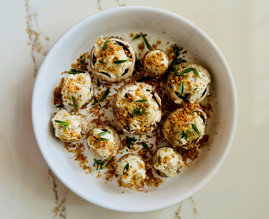 Stuffed cremini mushrooms filled with savory Italian sausage, chopped macadamia nuts, and topped with melted goat milk Tomme cheese, garnished with fresh parsley