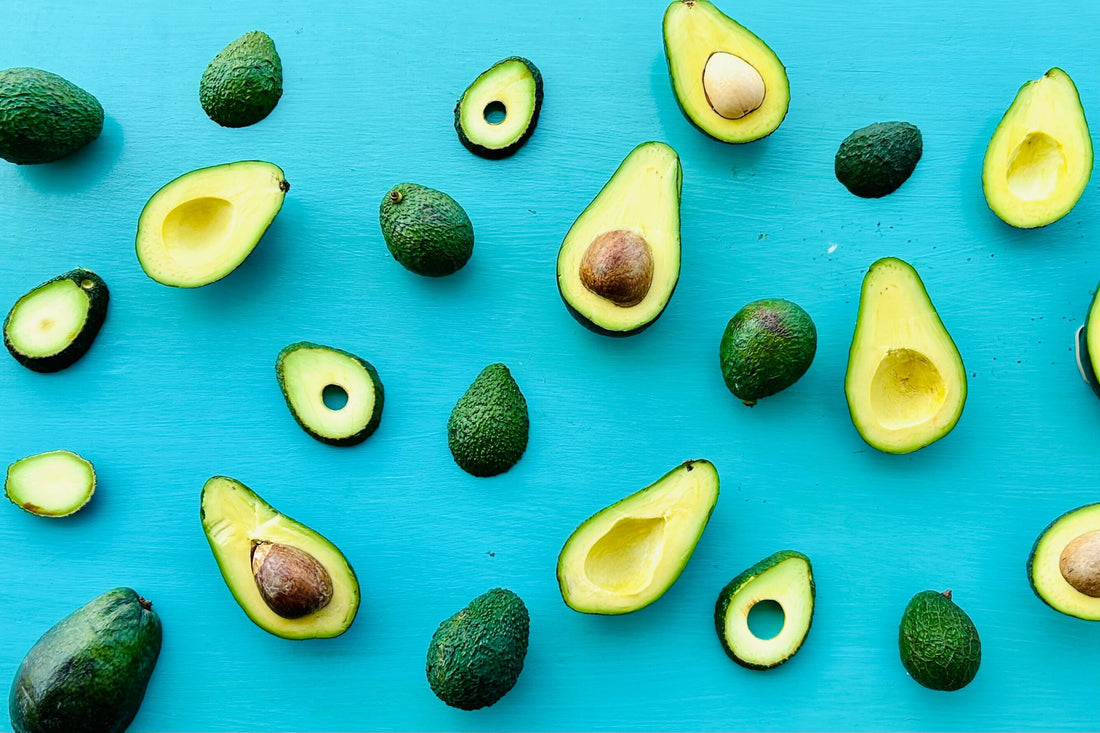 Ripe, Hawaii grown avocados sliced and arranged on a blue background